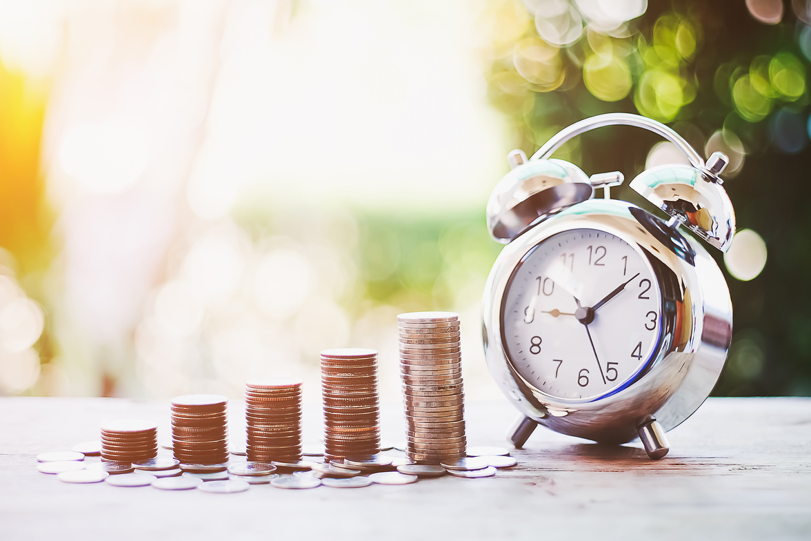 Close Up of Coins and Alarm Clock Outdoors