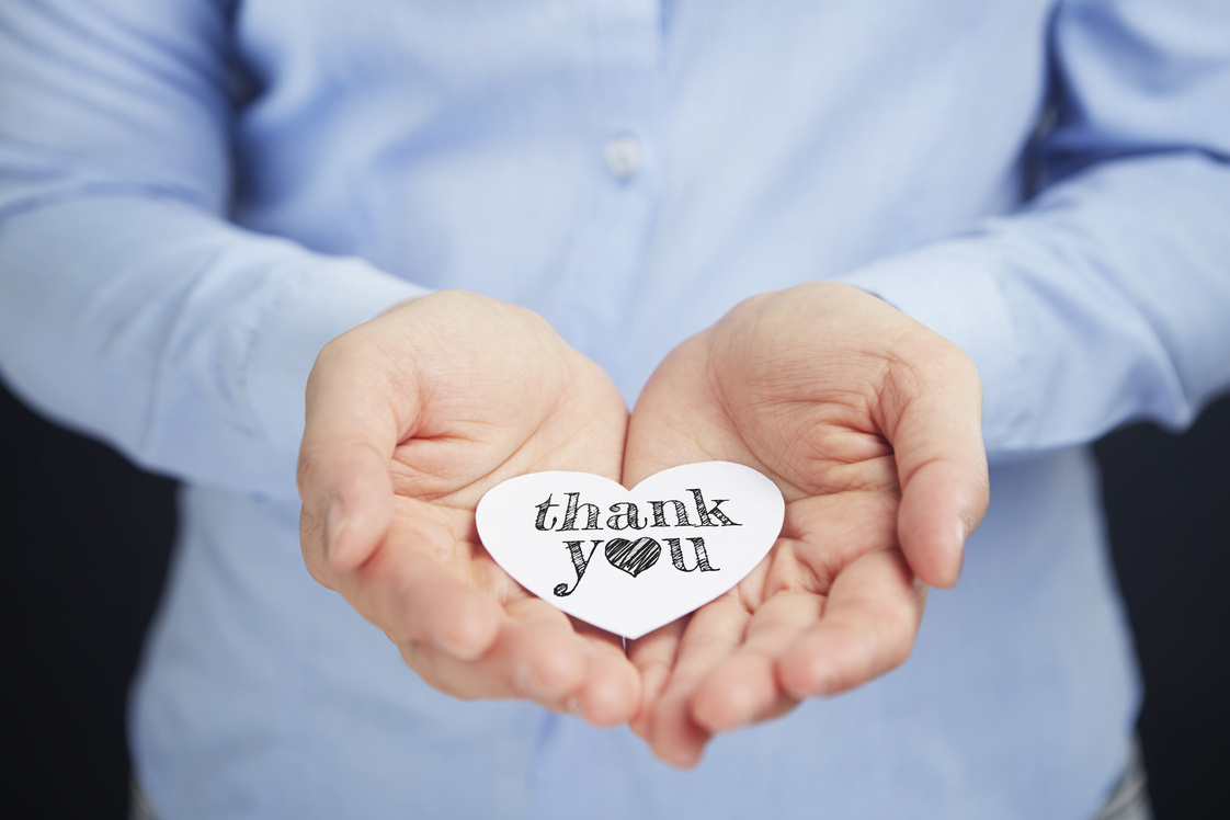 Hands presenting thank you card