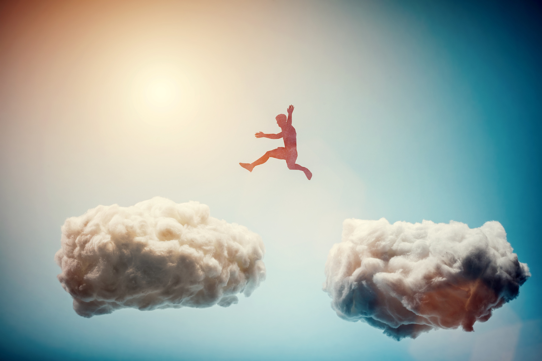 Man Jumping from One Cloud to Another