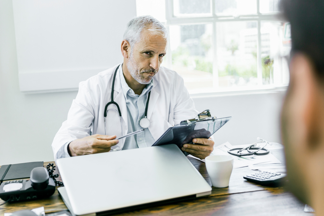 Suspicious doctor looking at patient in hospital